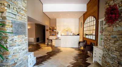 a kitchen and a living room with a stone wall at 2 bed 2 bath, 4 min walk to slope, Predela2, Bansko in Bansko