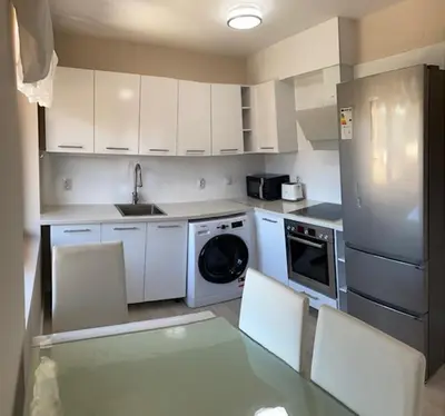 a kitchen with white cabinets and a sink and a dishwasher at 2 bed 2 bath, 4 min walk to slope, Predela2, Bansko in Bansko