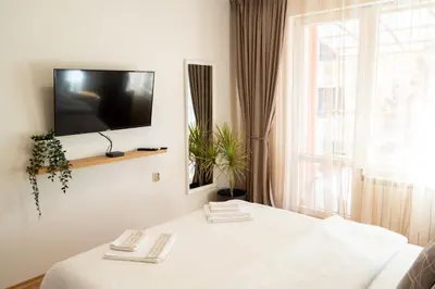 a room with a table with a tv on the wall at Maryland Apartment incl Private Garage in Sofia