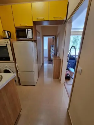 a kitchen with white appliances and yellow cabinets at Apartment's Ortakchiev 2 in Sofia