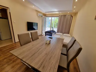 a living room with a wooden table and chairs at Apartment's Ortakchiev 2 in Sofia