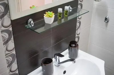 a bathroom sink with a glass shelf above it at Comfortable 2BR Urban Getaway in City Center by Flat Mаnager in Plovdiv