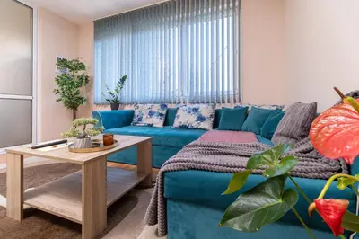 a living room with a blue couch and a table at Comfortable 2BR Urban Getaway in City Center by Flat Mаnager in Plovdiv