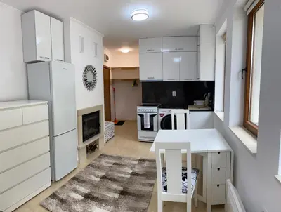 a kitchen with white cabinets and a white table and stool at Ski-in Ski-out Studio, Grand Monastery, Pamporovo in Pamporovo
