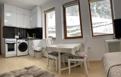 a kitchen with a table and chairs in a room at Ski-in Ski-out Studio, Grand Monastery, Pamporovo in Pamporovo