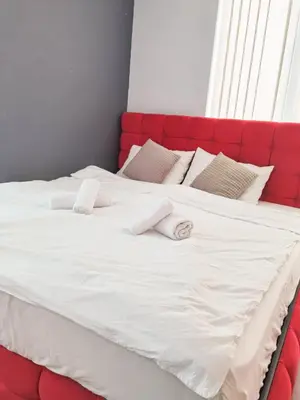 a large white bed with a red head board at Boutique Apartment in Plovdiv