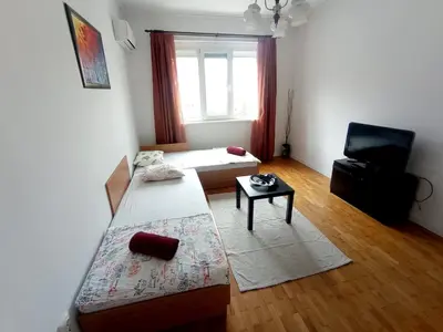 a room with two beds and a chair in it at Lovely 1 bdr apartment in Sofia city center in Sofia