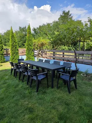 a black picnic table and benches in the grass at Shekerdejiiski guest house bansko in Bansko
