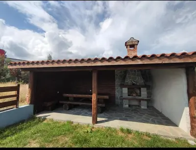a patio with a fireplace in a house at Shekerdejiiski guest house bansko in Bansko