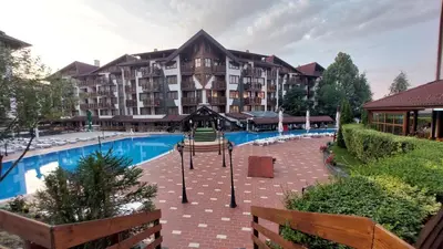 a large apartment building with a large swimming pool at Belvedere Holiday Club - Mountain View in Bansko