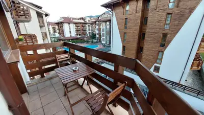 a balcony with a bench and a view of a pool at Belvedere Holiday Club - Mountain View in Bansko