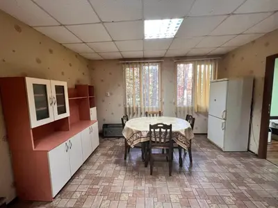 a kitchen with a table and chairs in a room at Почивна база Пиринпласт in Gotse Delchev