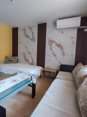 a room with two beds and a wall with marble at Апартамент Родопи in Smolyan