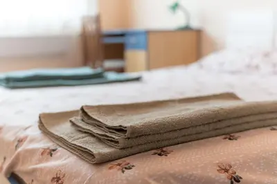 a pile of towels sitting on top of a bed at Cozy Apart TOP Center AUBG Free Garage Parking in Blagoevgrad