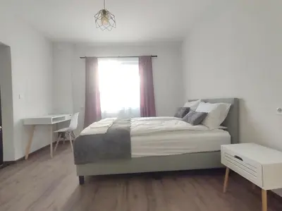 a bedroom with a bed with a window and a desk at Cozy Rooms Panagyurishte in Panagyurishte