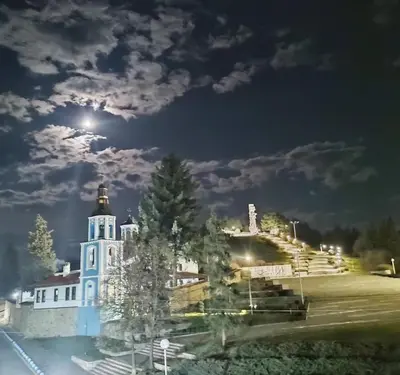 a large white building with a light on top at night at Cozy Rooms Panagyurishte in Panagyurishte