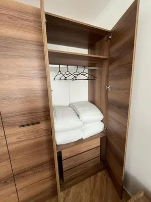 a small closet with white towels on a shelf at COZY ski-to-door apartment, Monastery 3 complex in Pamporovo