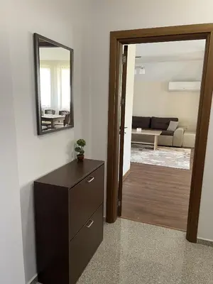 a living room with a dresser and a mirror at Panorama view apartment in Sandanski