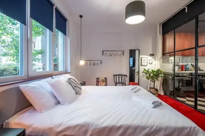 a large white bed in a room with windows at Central Art-Inspired Flat with Private Garage in Sofia