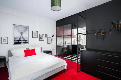 a bedroom with a white bed and a red rug at Central Art-Inspired Flat with Private Garage in Sofia