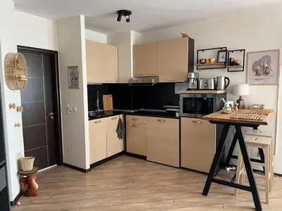 a kitchen with wooden cabinets and a table in it at Luxury Studio in Alpinе Lodge FREE SPA in Bansko