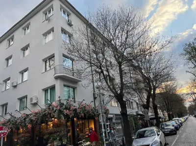 a white building on a street with a store at The Heart of Old Sofia (Shipka Street 24) in Sofia