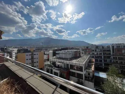 a city with buildings and the sun in the sky at Silver city in Sofia