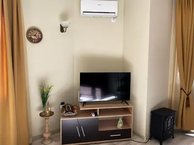 a tv sitting on a stand in a living room at DeLuxe Apartment 2OOm from Gondola in Bansko