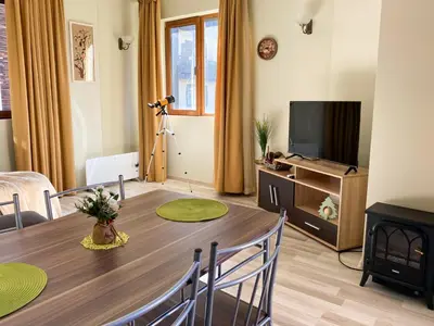 a living room with a table and a television at DeLuxe Apartment 2OOm from Gondola in Bansko