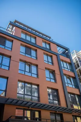 a tall building with windows on the side of it at Geneva: A charming patio studio with private parking! in Sofia
