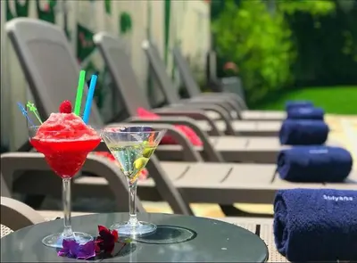 a table with two drinks on a table with chairs at Хотел Стиляна/Hotel Stilyana in Devin