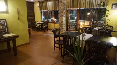 a dining room with tables and chairs in a restaurant at Хотел Стиляна/Hotel Stilyana in Devin