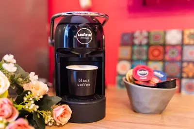 a black coffee maker sitting on a table with flowers at Beauty downtown - TOP CENTER in Sofia