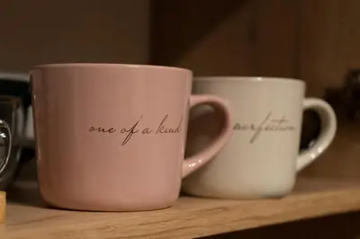 three coffee cups sitting on a wooden shelf at Urban Elegance by Eagles' Bridge in Sofia