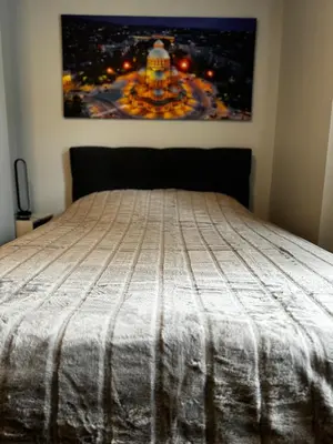 a bed in a bedroom with a picture on the wall at Urban Elegance by Eagles' Bridge in Sofia