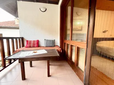 a small balcony with a bench and a bed at Vila Omainiche Ribarica in Ribarica