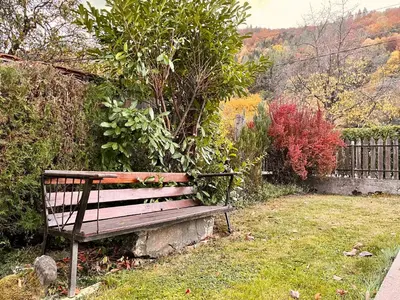 a park bench sitting in the grass next to a fence at Vila Omainiche Ribarica in Ribarica