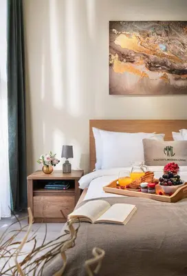 a tray of fruit on a bed with a book at New, Modern And Convenient in Sofia