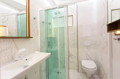 a bathroom with a glass shower and a toilet at Central Vitosha Apartment in Sofia