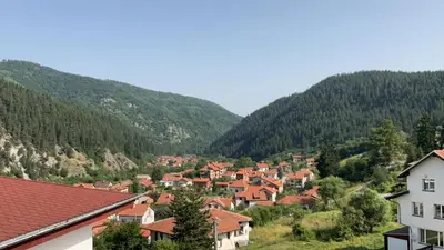 a town in a valley with mountains in the background at Alpine Nest: 6km to ski slopes in Beli Iskar