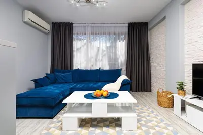 a living room with a blue couch and a table at Super Center flat Parchevich in Plovdiv