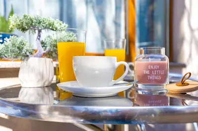 a table with a coffee cup and a glass of orange juice at Super Center flat Parchevich in Plovdiv