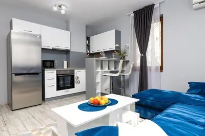 a kitchen and a living room with a blue couch at Super Center flat Parchevich in Plovdiv