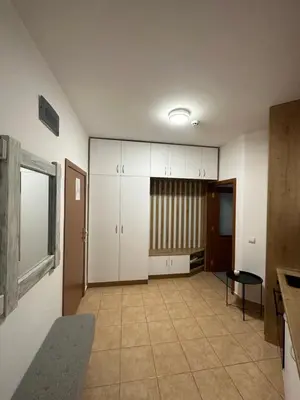 a room with a kitchen with white cabinets and a table at Апартхотел Флора 213Б in Borovets