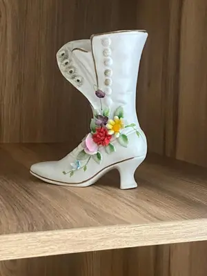 a white boot with flowers on it sitting on a shelf at Casa Dell'Arte in Sofia