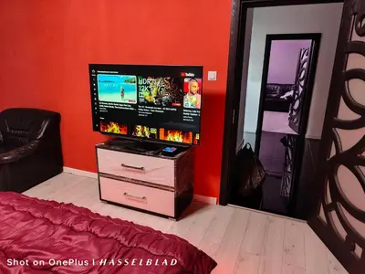a room with a television on a dresser with a mirror at Тристаен апартамент в центъра in Sofia