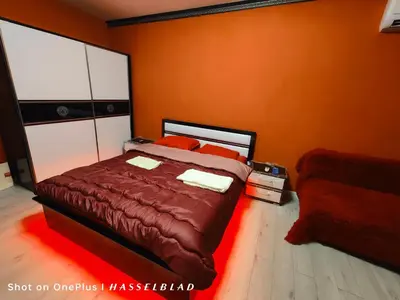 a bedroom with a bed and a red wall at Тристаен апартамент в центъра in Sofia