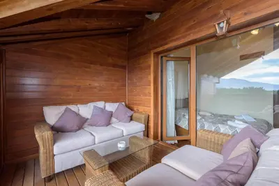 a living room with a couch and a bedroom at Уютен апартамент с гледка в к-с Пирин Голф in Razlog