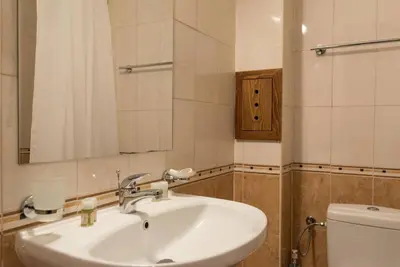 a bathroom with a white sink and a toilet at Уютен апартамент с гледка в к-с Пирин Голф in Razlog