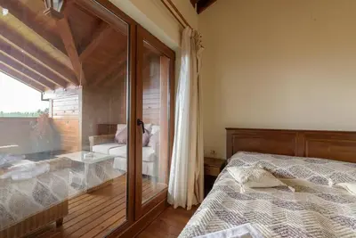 a bedroom with a bed and a glass window at Уютен апартамент с гледка в к-с Пирин Голф in Razlog
